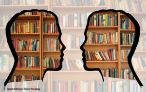 Silhouette zweier Menschen vor einer Bibliothek